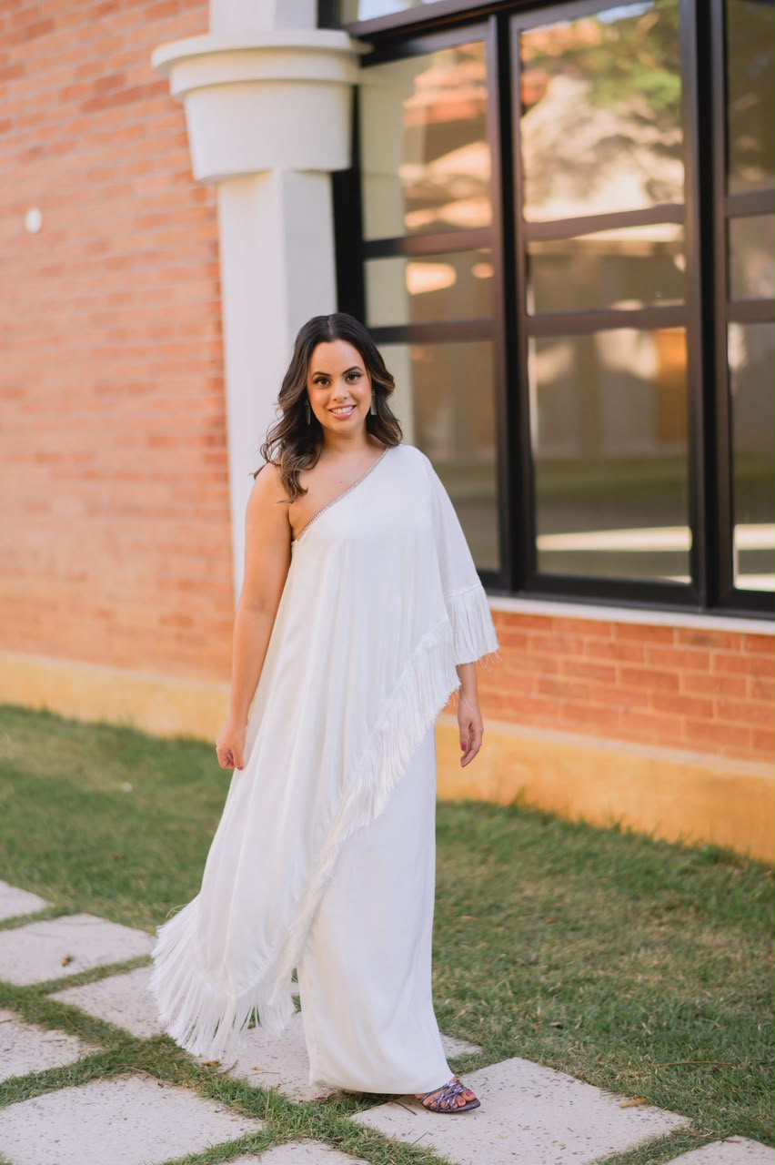 Carol Regazi sorrindo com vestido branco em ensaio externo